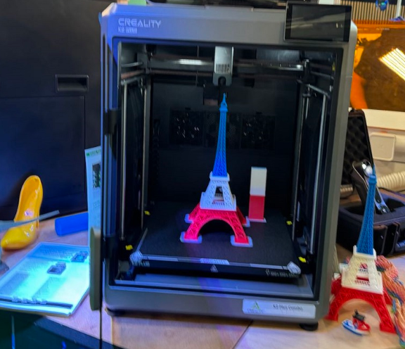 A 3D printer with a small model of a tower inside