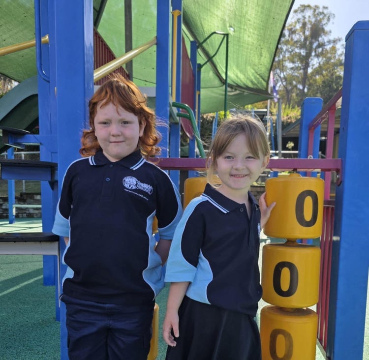 Two Trunkey Public School kindergarten students standing at the play equipment.