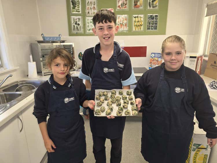 3 students holding their food before it goes in the oven