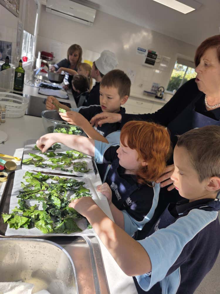 3 students preparing kale chips with Mrs Haussener