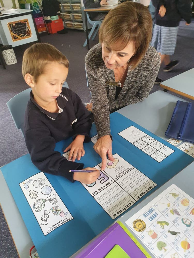 An SLSO working with a student in the classroom