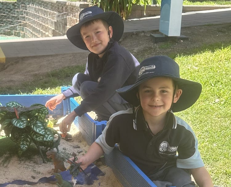 2 students playing in the dinosaur garden
