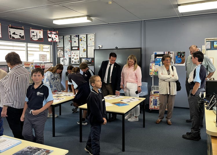 Community members and staff gathered in the library to look at the ANZAC day display on the walls and tables