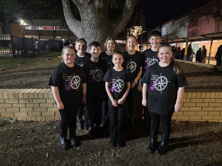 8 students standing together wearing black Compass Music Festival t-shirts